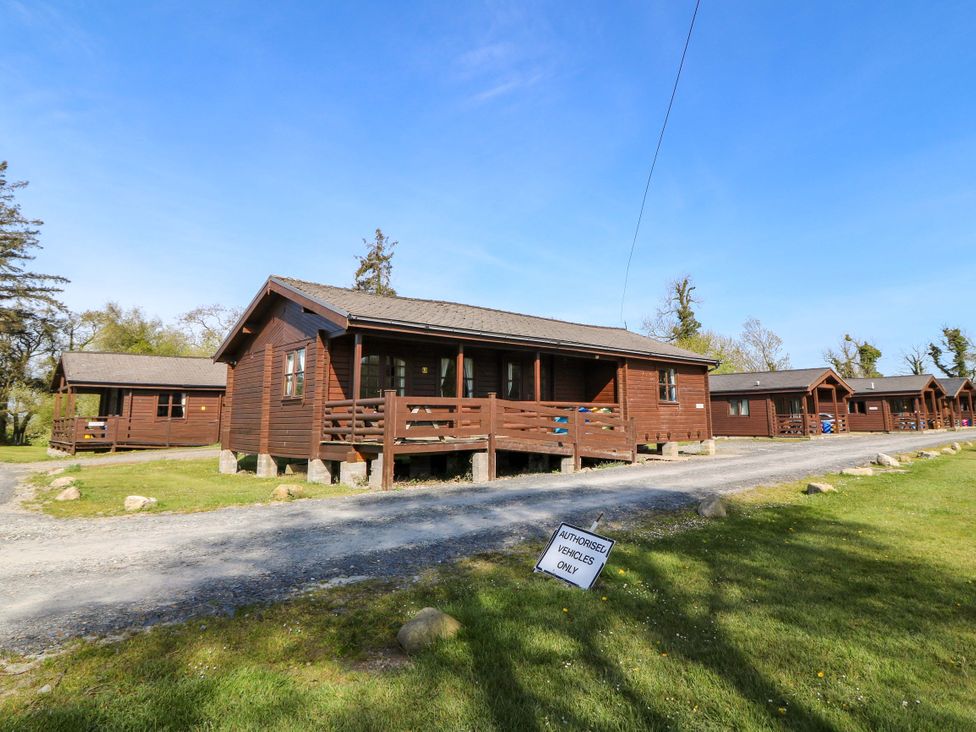 A log cabin with a pathway and grass area at Lodge 9 - Sleep 4 - Double and Twin in Criccieth