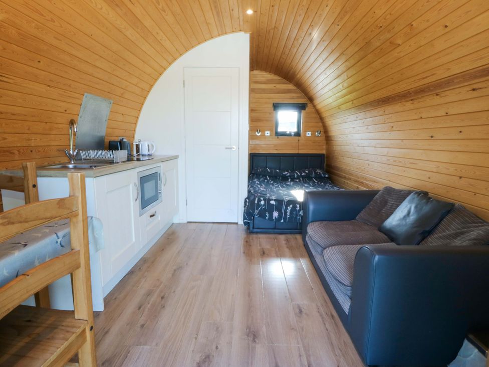 A kitchenette with a sofa and bed at Bron Eifion Pod 3 Criccieth
