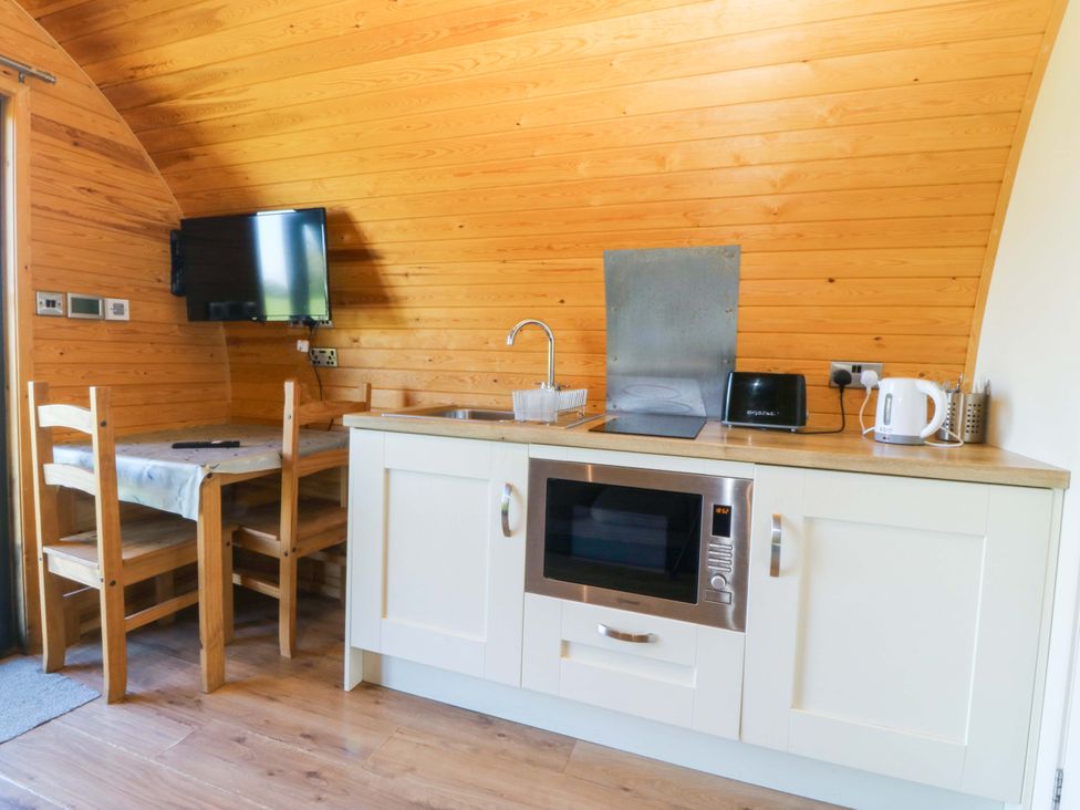 A kitchen with a table and chairs at Bron Eifion Pod 5 in Criccieth