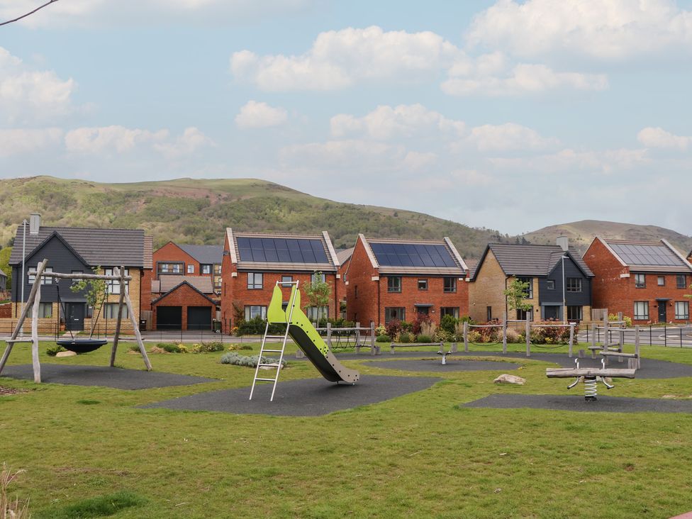 A playground with swings and slides beside residential houses at 56 Strothers Avenue