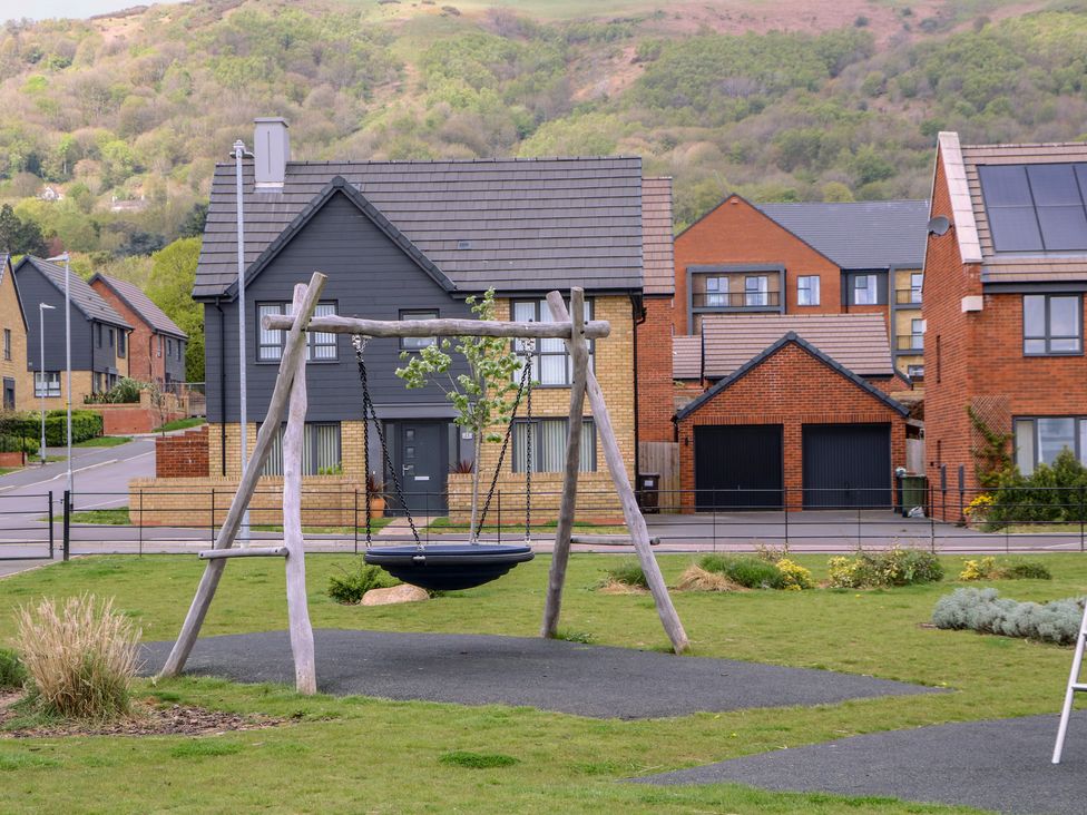 A swing in a grassy area near houses at 56 Strothers Avenue