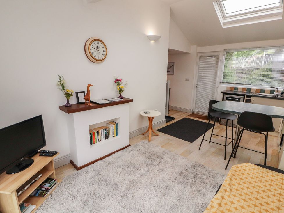 A living room with a television and a dining area at Juniper Hayloft in Ambleside