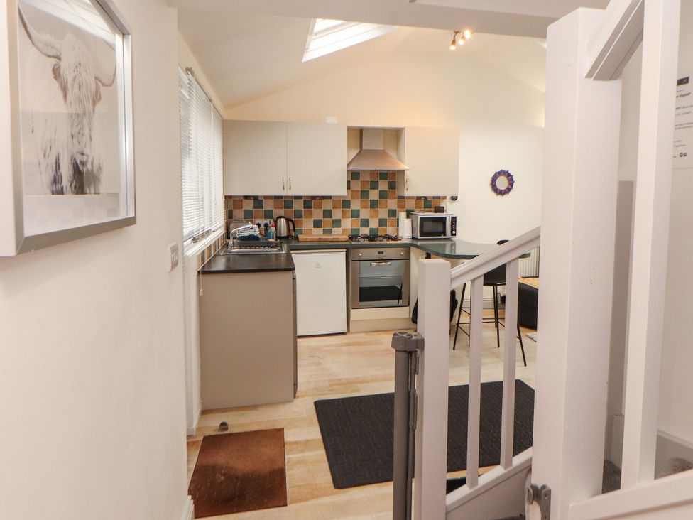 A kitchen with appliances and seating at Juniper Hayloft in Ambleside