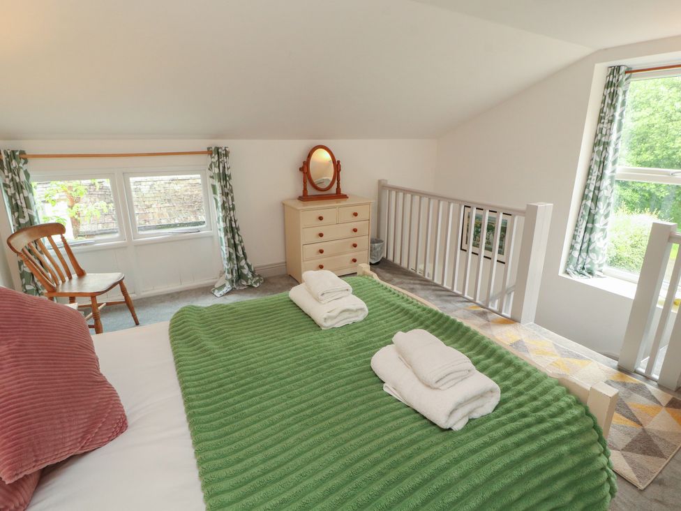 A bedroom with bedsheets and towels at Juniper Hayloft in Ambleside