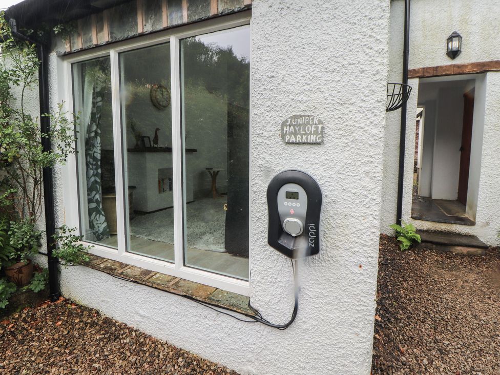An outdoor view of the parking area with a charging station at Juniper Hayloft in Ambleside
