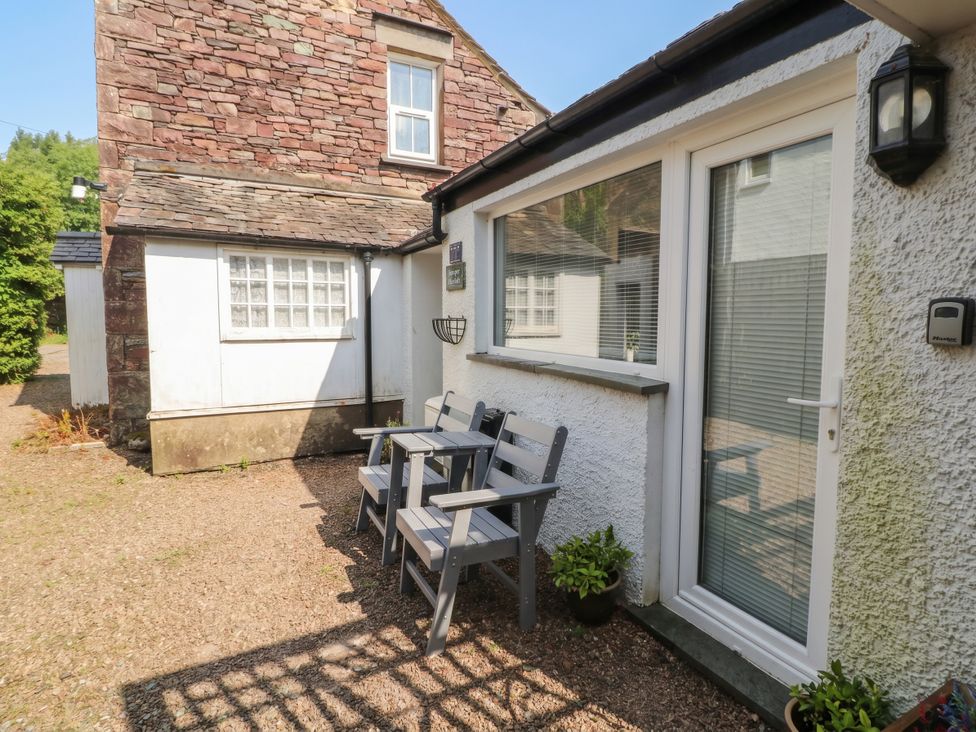 An outdoor area with chairs and a door at Juniper Hayloft Ambleside