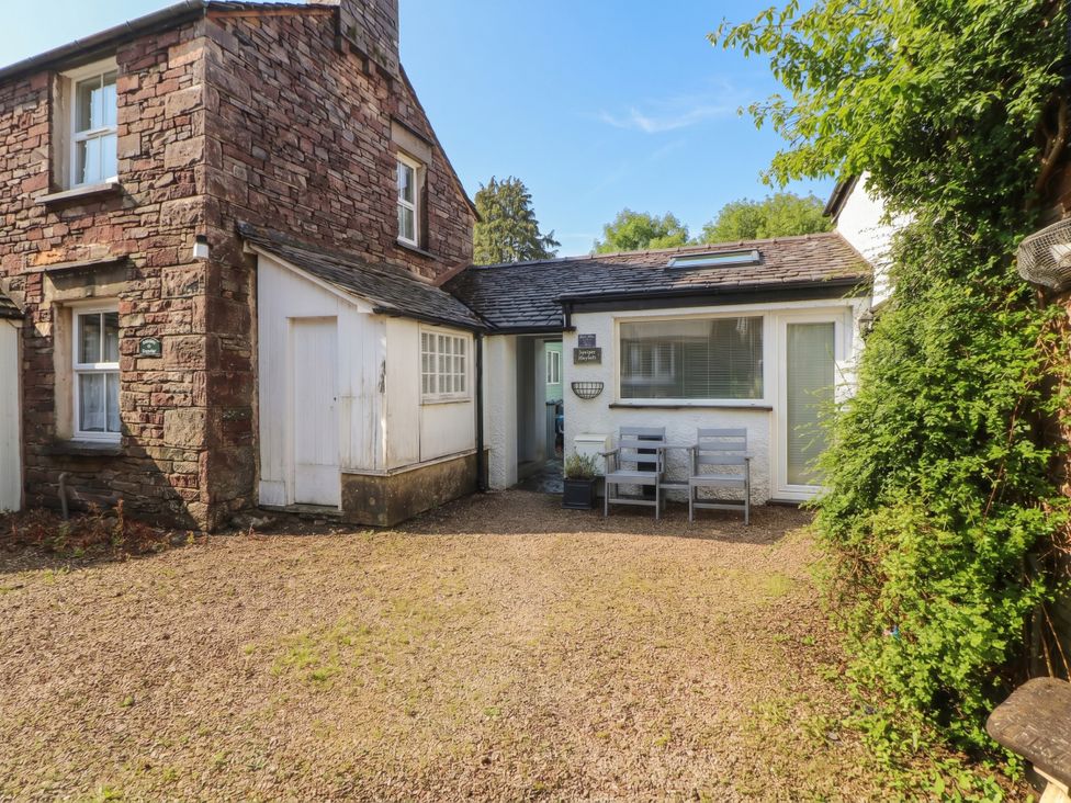 A house with chairs and gravel area at Juniper Hayloft in Ambleside