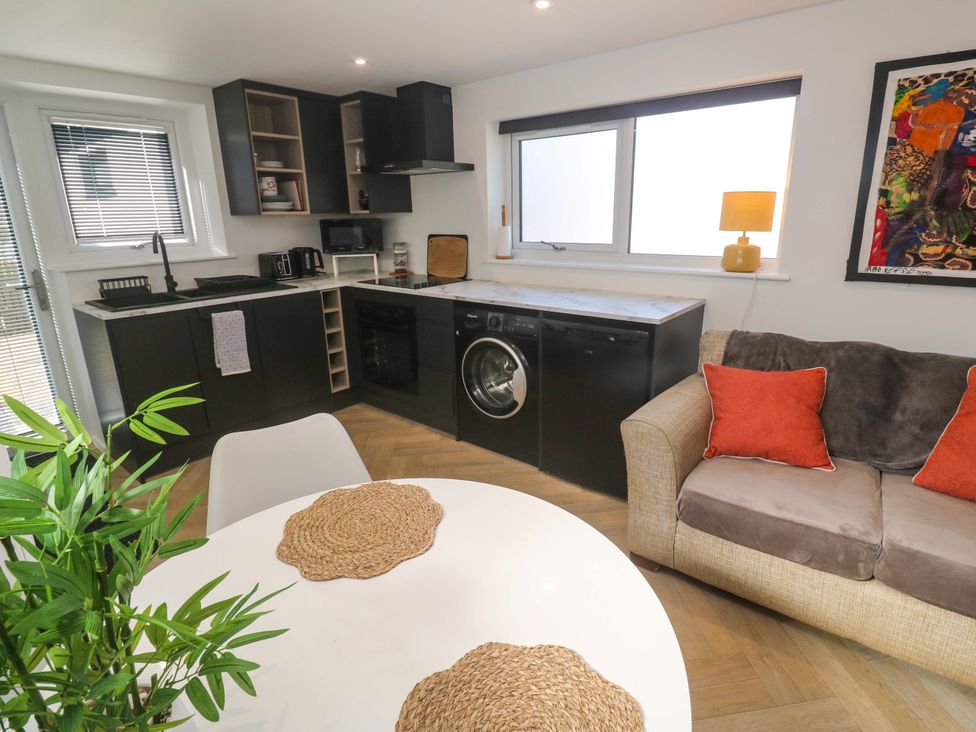 A kitchen with appliances and seating area at The Annex in Penzance