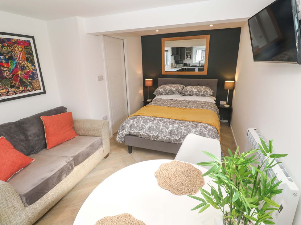 A bedroom with a bed, sofa and table at The Annex in Penzance