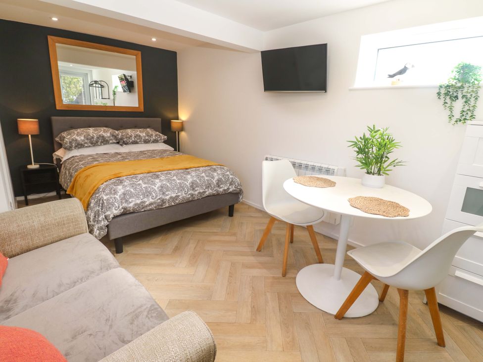A bedroom with a bed and dining table at The Annex in Penzance