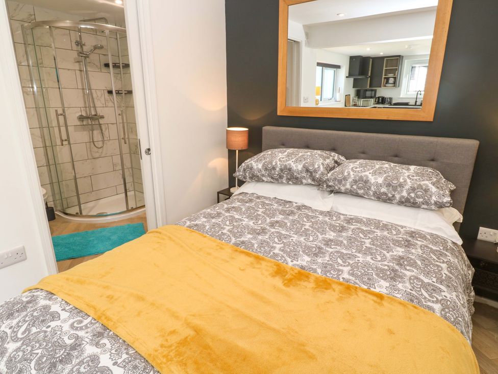 A bedroom with a bed and a shower area at The Annex Penzance