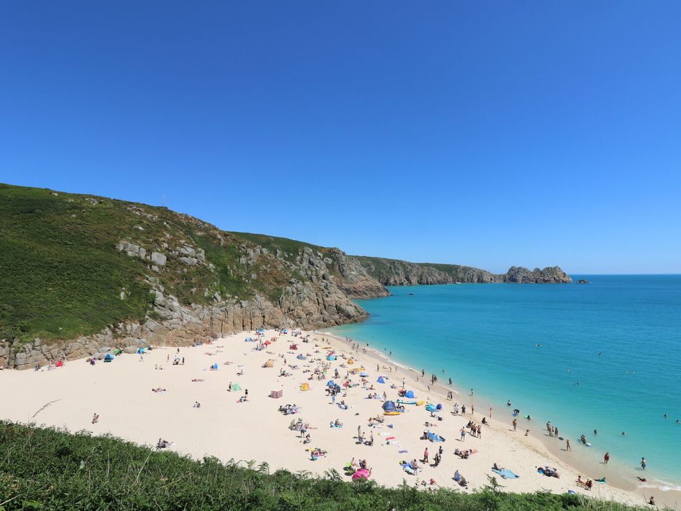 A beach with people and umbrellas at The Annex in Penzance