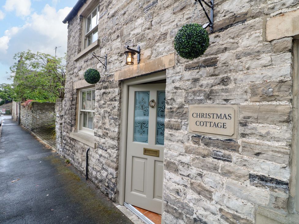 The entrance of Christmas Cottage in Bakewell with a stone wall and door