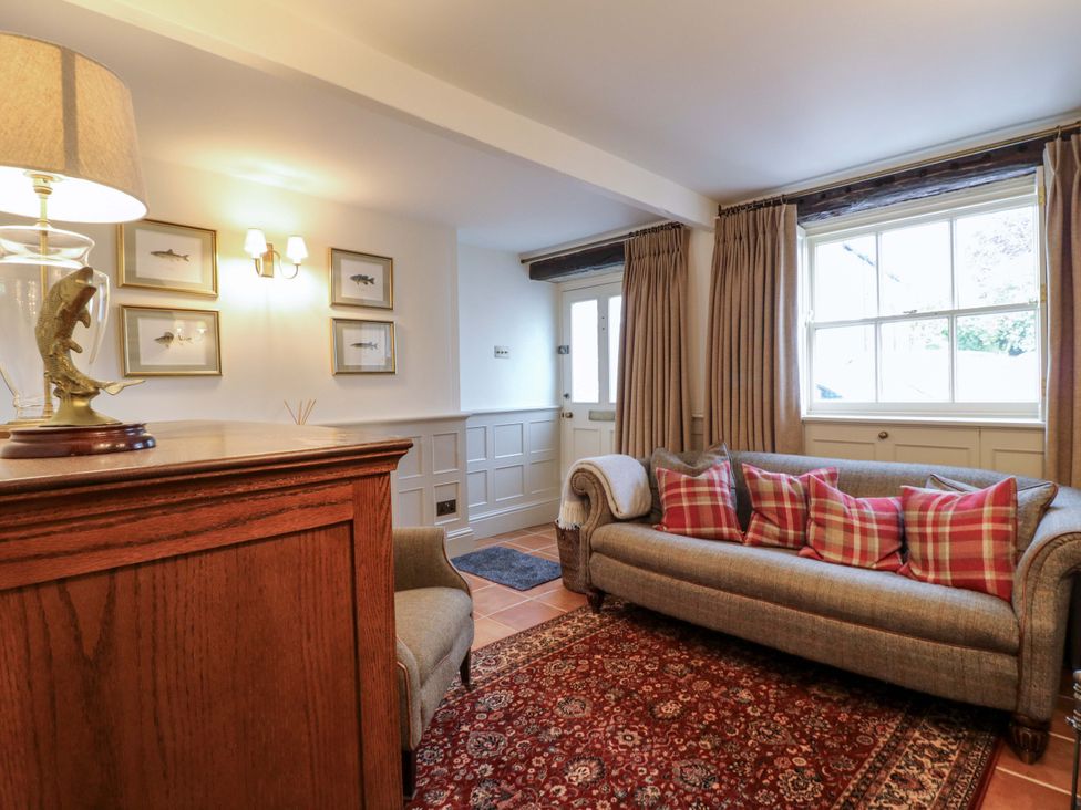 A living room with a sofa and lamp at Christmas Cottage in Bakewell