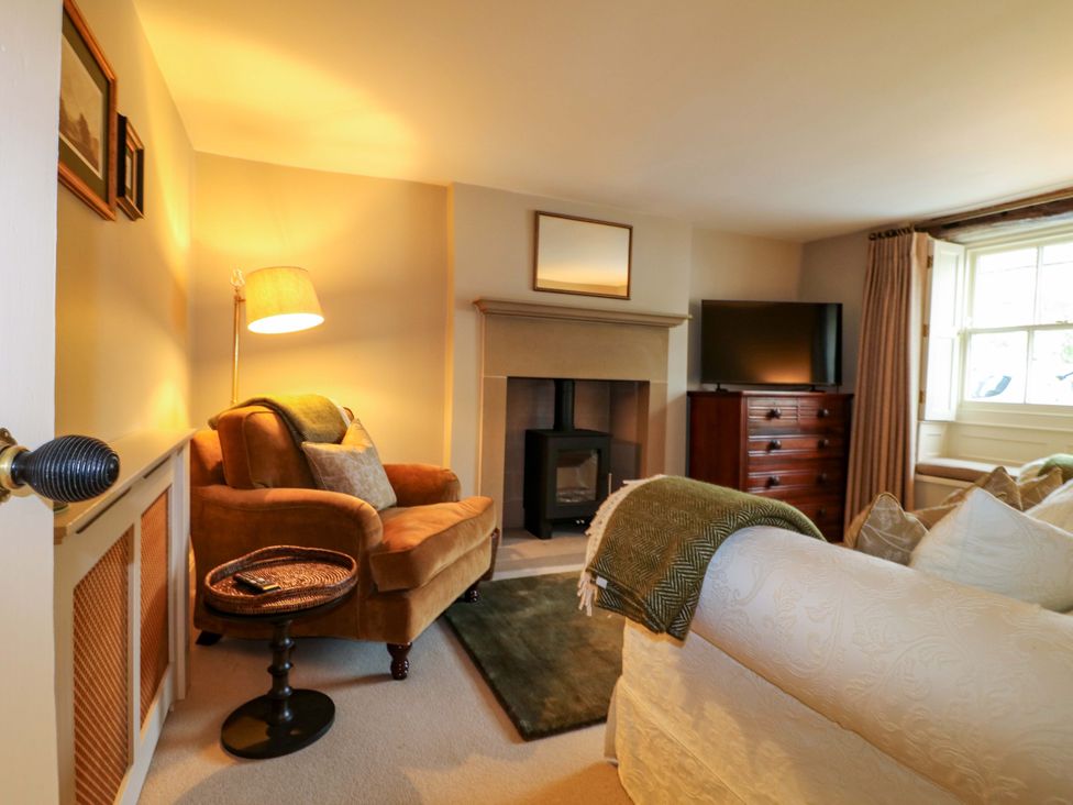 A living room with an armchair and television at Christmas Cottage in Bakewell