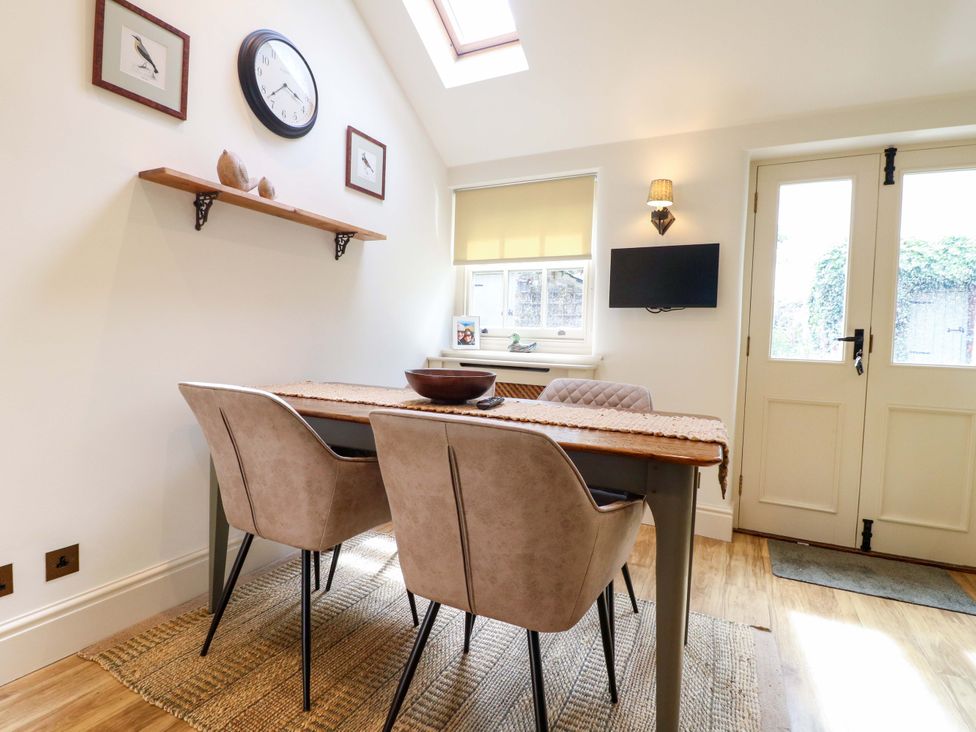 A dining room with a table and chairs at Christmas Cottage in Bakewell