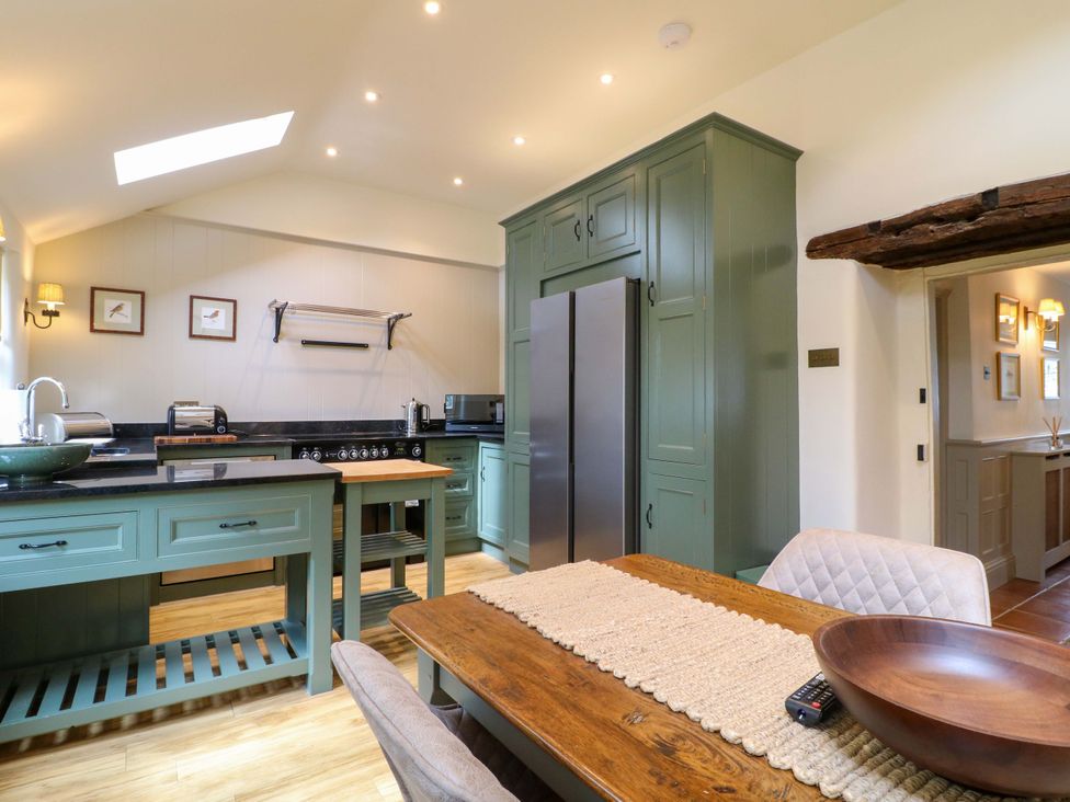 A kitchen with a table and appliances at Christmas Cottage in Bakewell