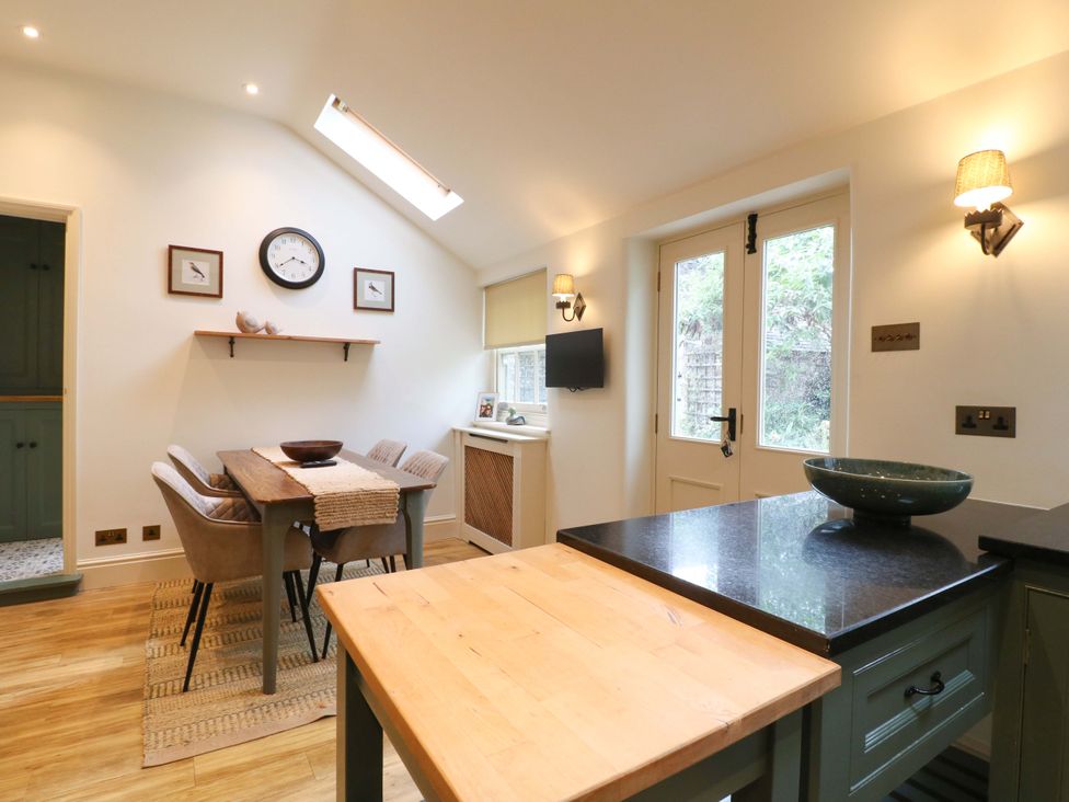 A kitchen with a dining table and chairs at Christmas Cottage in Bakewell