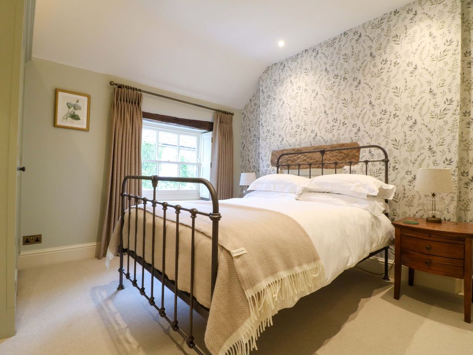 A bedroom with a bed and bedside table at Christmas Cottage in Bakewell