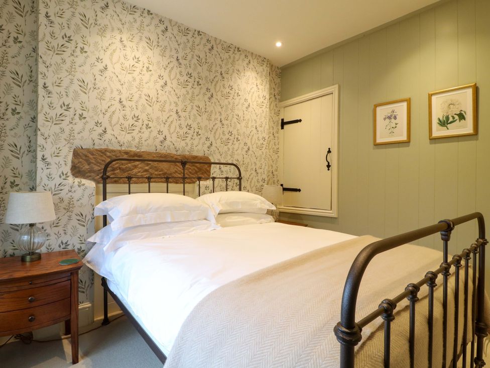 A bedroom with a bed and nightstand at Christmas Cottage in Bakewell