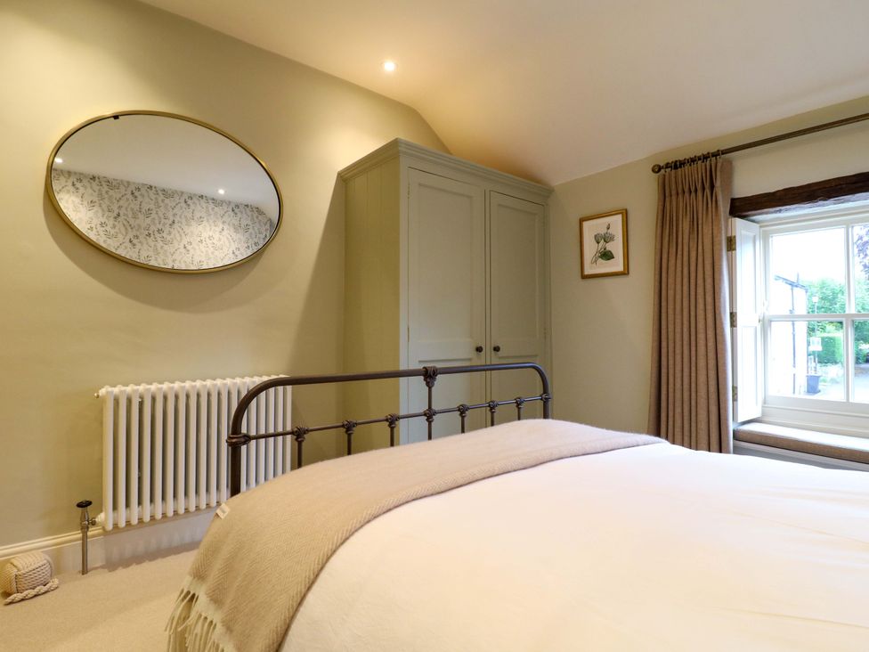 A bedroom with a bed and wardrobe at Christmas Cottage in Bakewell