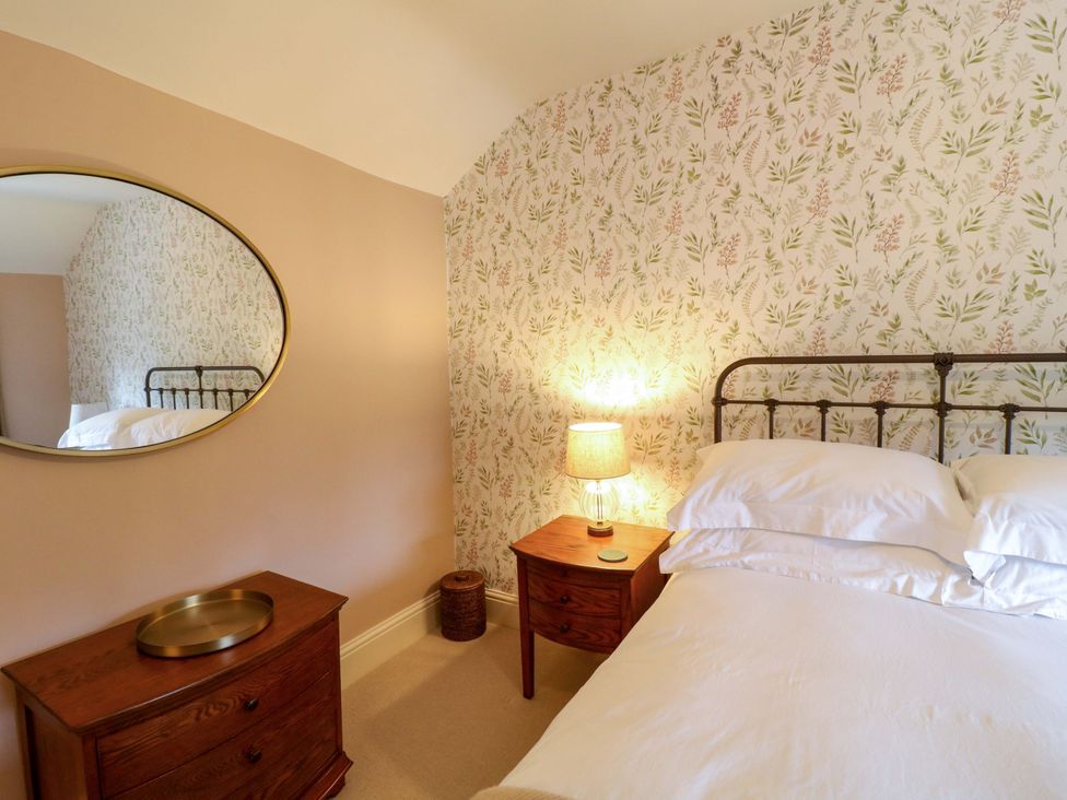A bedroom with a bed and bedside table at Christmas Cottage in Bakewell