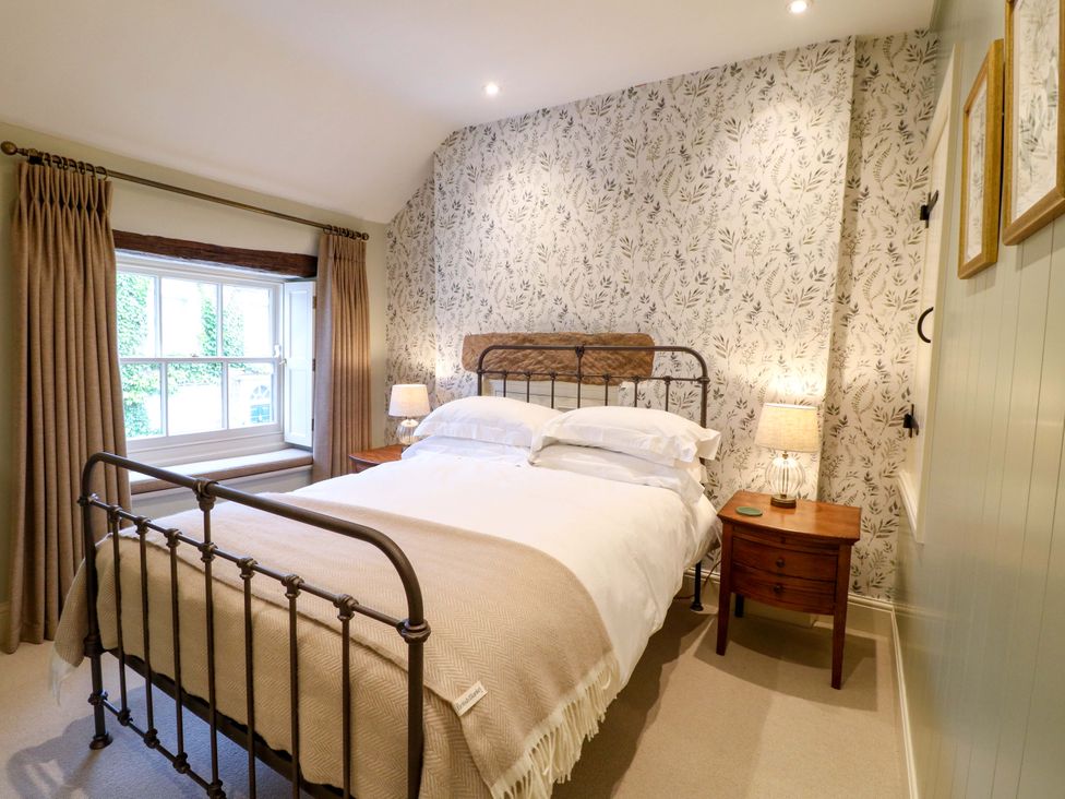 A bedroom with a bed and bedside table at Christmas Cottage in Bakewell