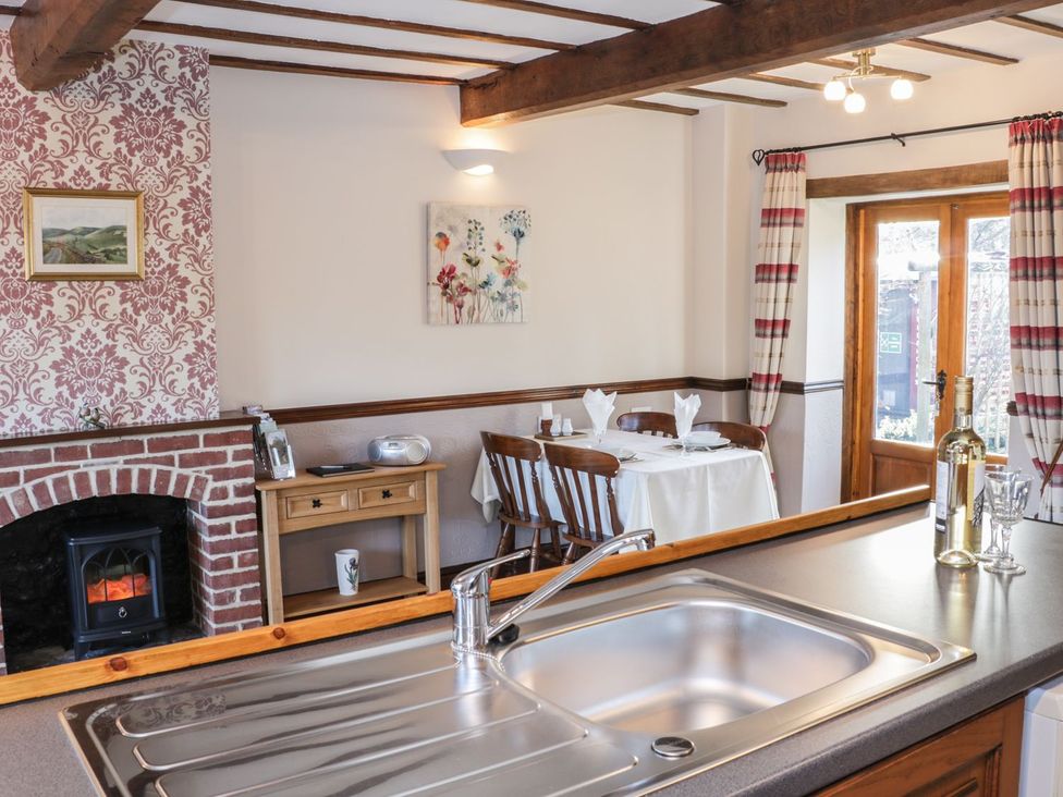 A kitchen with a sink and dining area at The Granary in Bucknell