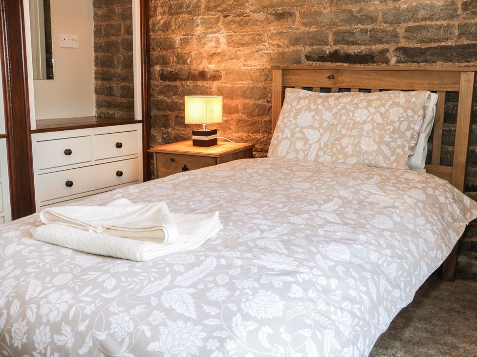 A bedroom with a bed and bedside table at The Granary in Bucknell