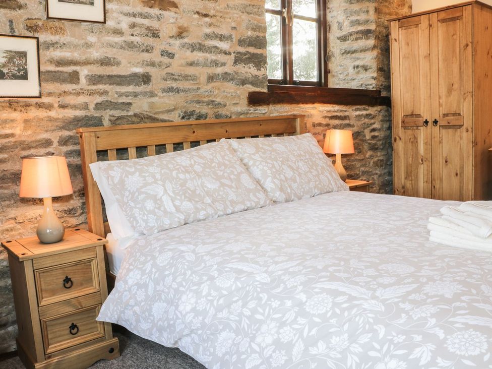 A bedroom with a bed and wooden furniture at The Granary in Bucknell