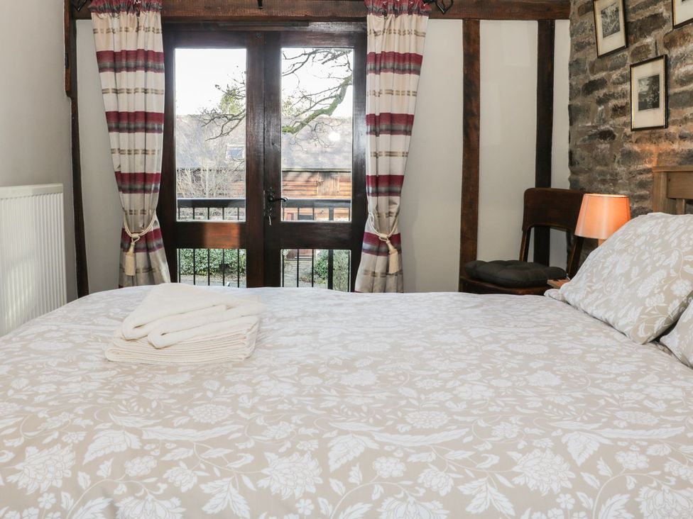 A bedroom with a bed and window at The Granary in Bucknell