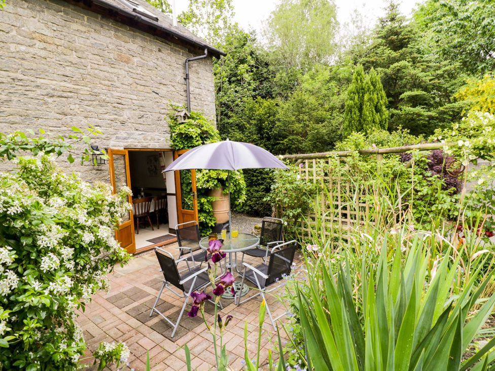 A garden with a table and chairs under an umbrella at The Granary in Bucknell