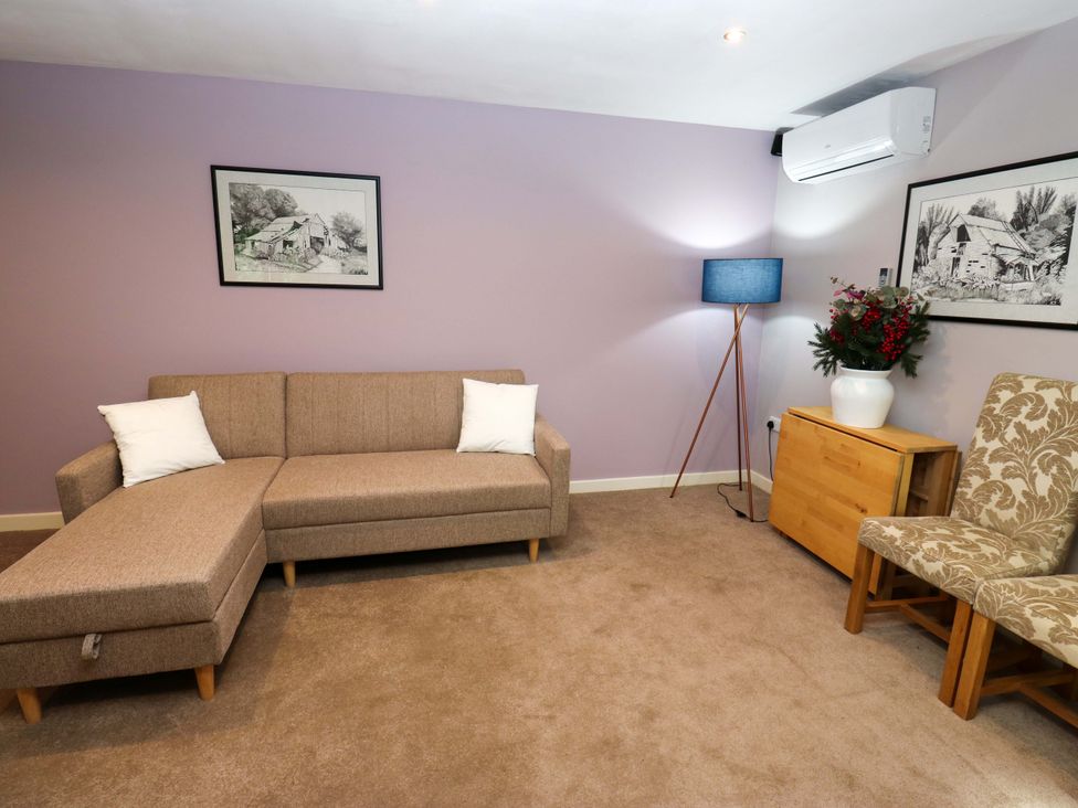 A living room with a sofa and a lamp at The Lodge in Brighouse