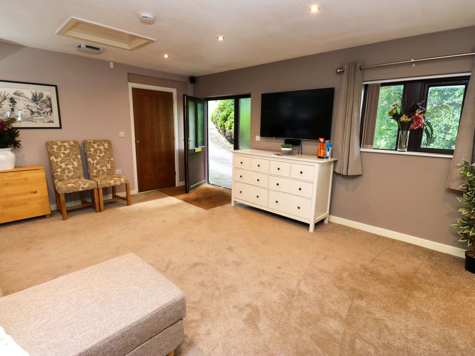 A sitting room with a sofa and television at The Lodge in Brighouse