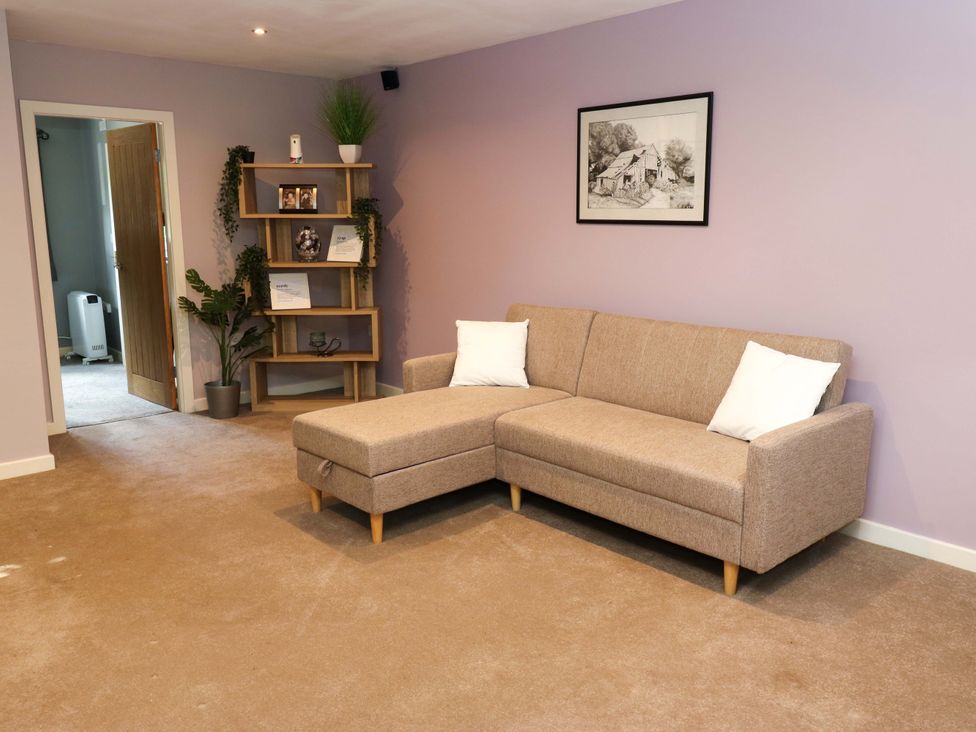 A living room with a sofa and shelves at The Lodge in Brighouse