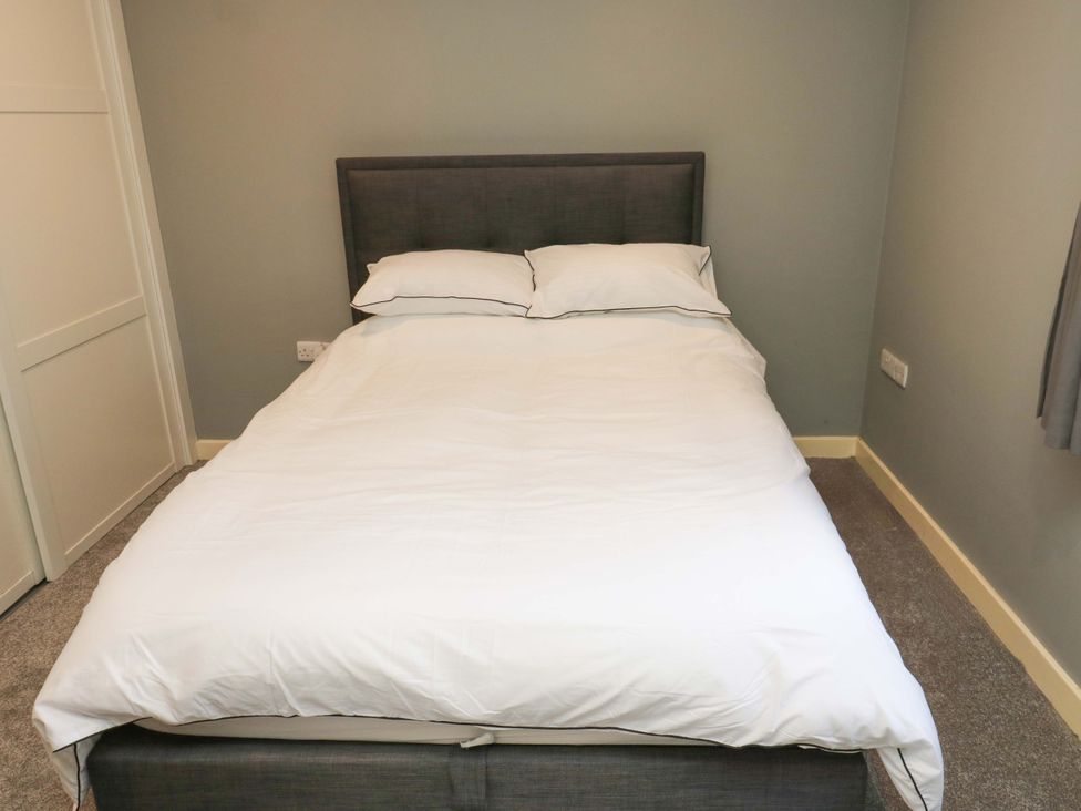 A bedroom with a bed and pillows at The Lodge in Brighouse