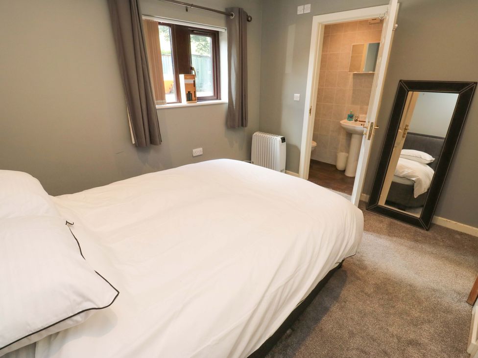 A bedroom with a bed and a window at The Lodge in Brighouse