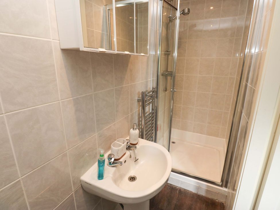 A bathroom with a shower and sink at The Lodge in Brighouse