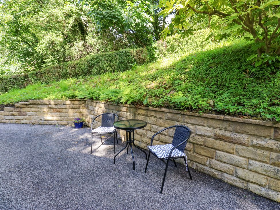 A garden area with a table and chairs at The Lodge in Brighouse
