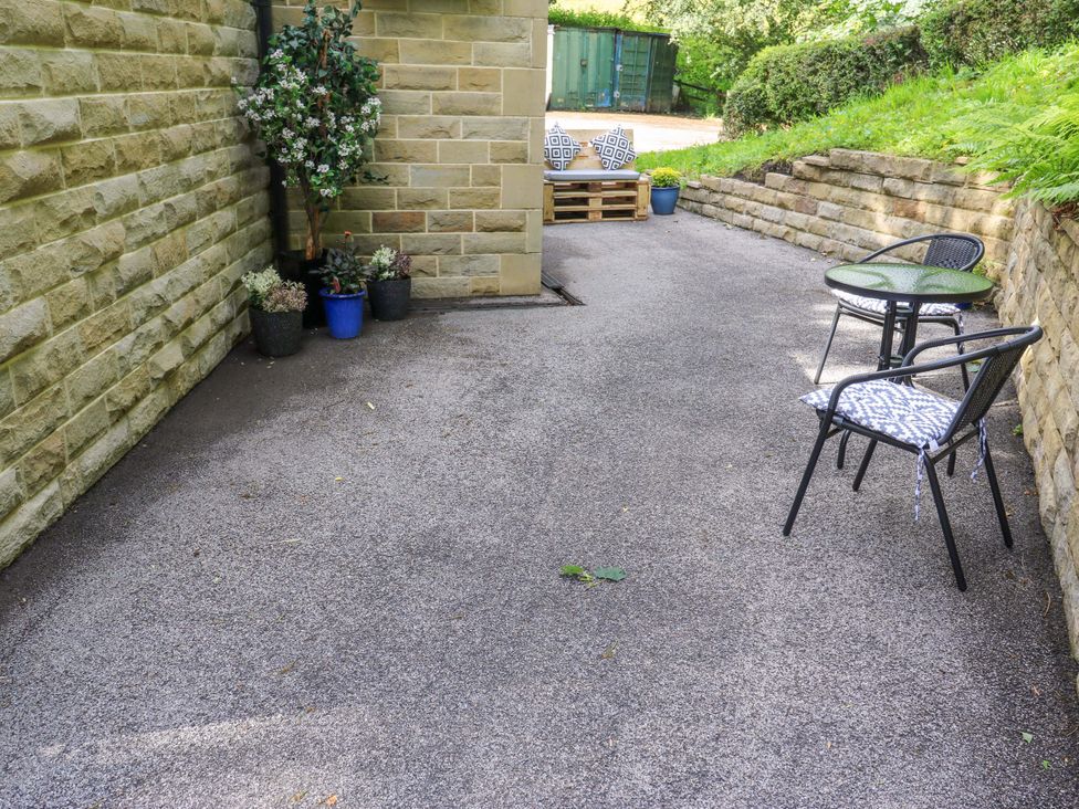 A garden area with chairs and a table at The Lodge in Brighouse