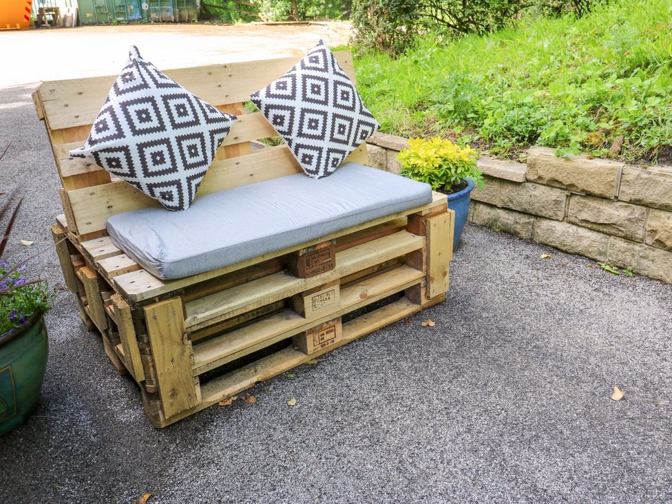A pallet sofa with cushions and a planter at The Lodge in Brighouse