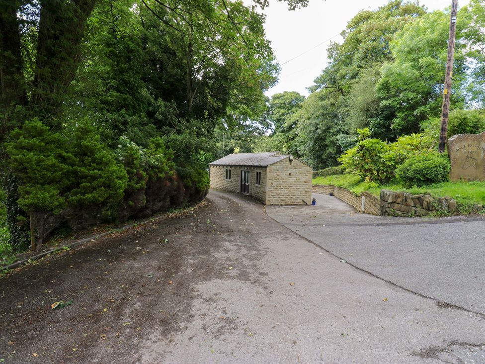 An outdoor area with a house and trees at The Lodge in Brighouse