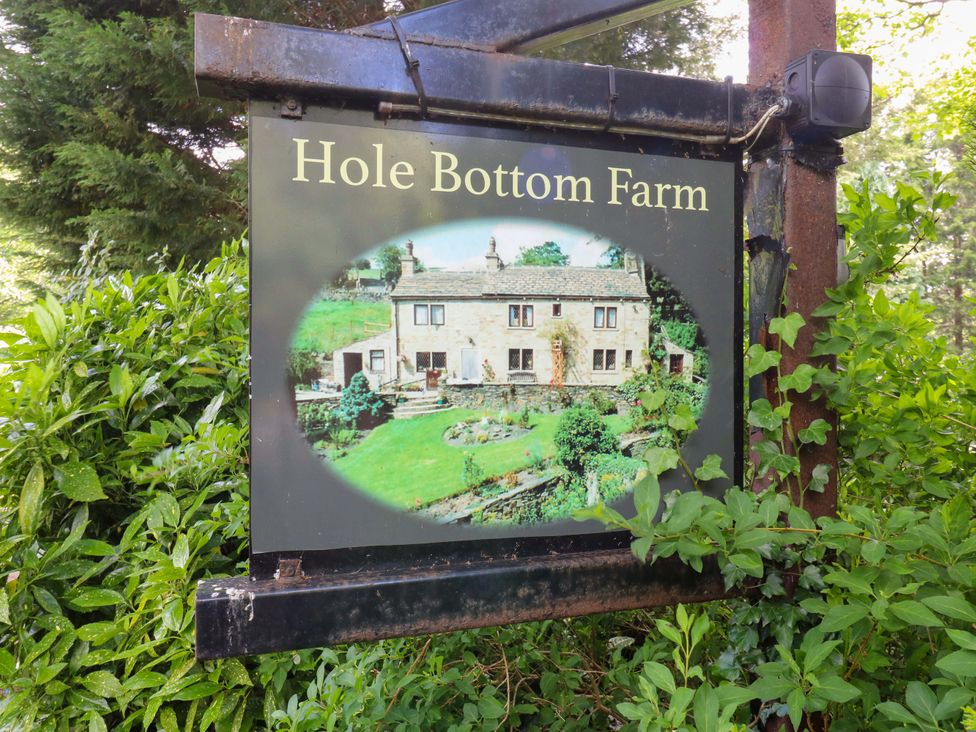 A sign for Hole Bottom Farm with an image of the farm in Brighouse
