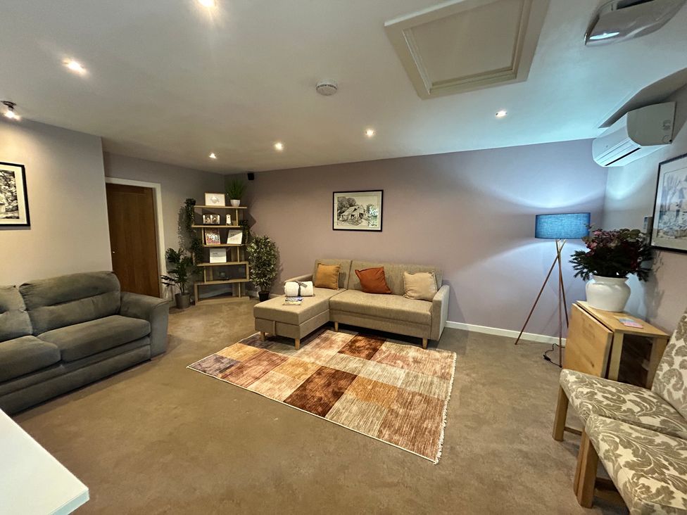 A living room with a sofa and shelves at The Lodge in Brighouse