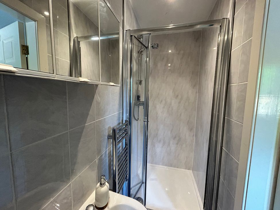 A bathroom with a shower and sink at The Lodge in Brighouse