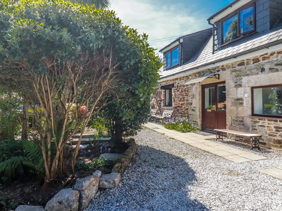 An outdoor area with a bush and gravel path at Camelia Cottage in St. Austell