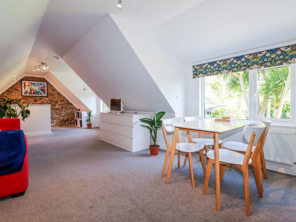 A dining room with a table and chairs at Camelia Cottage in St. Austell
