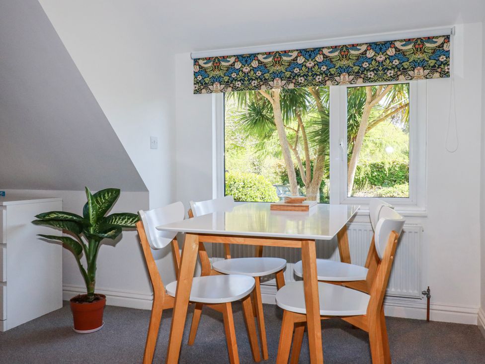 A dining room with table and chairs at Camelia Cottage in St. Austell