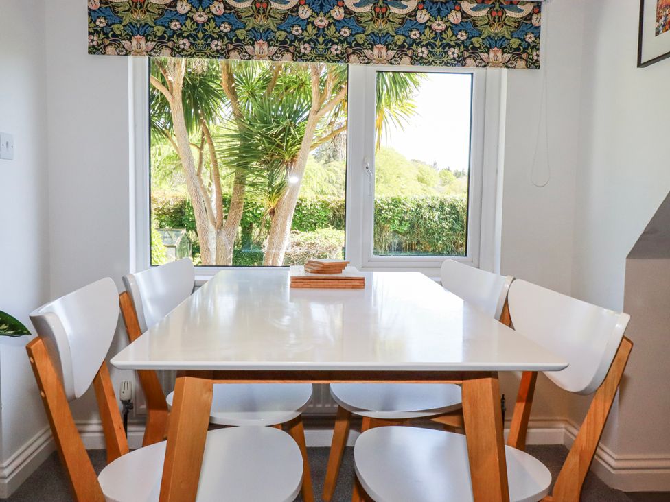 A dining room with a table and chairs at Camelia Cottage in St. Austell