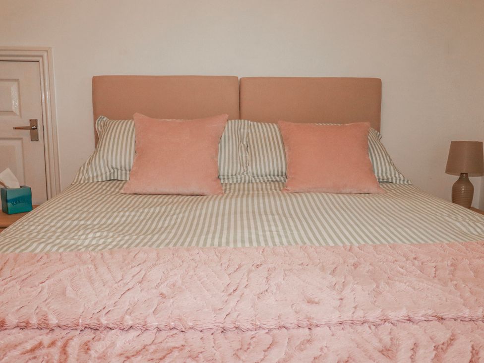 A bed with pillows in a bedroom at Camelia Cottage St. Austell